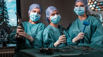 Drei Frauen posieren mit medizinischen Werkzeugen