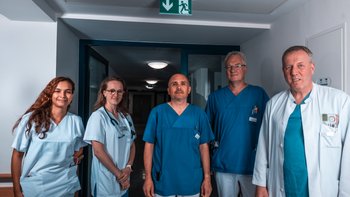 Fünf Menschen posieren vor der Kamera