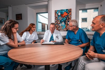 Fünf Menschen sitzen an einem Tisch
