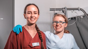 Zwei Frauen lächeln vor der Kamera