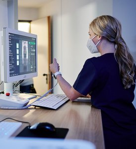 Frau in Profilansicht am Rechner